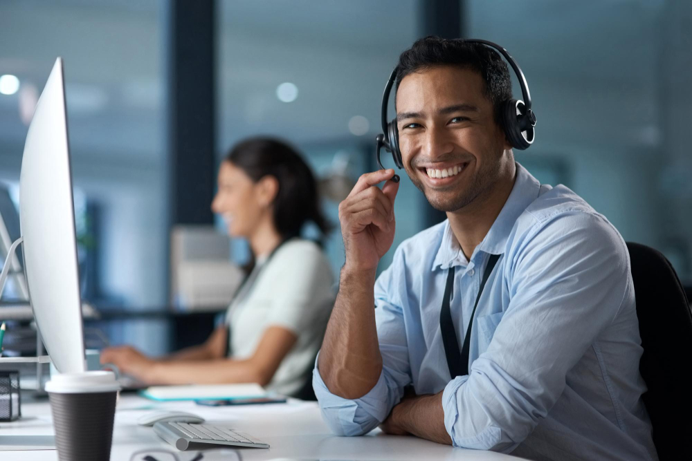 our-customer-satisfaction-rate-says-it-all-portrait-young-man-using-headset-computer-modern-office